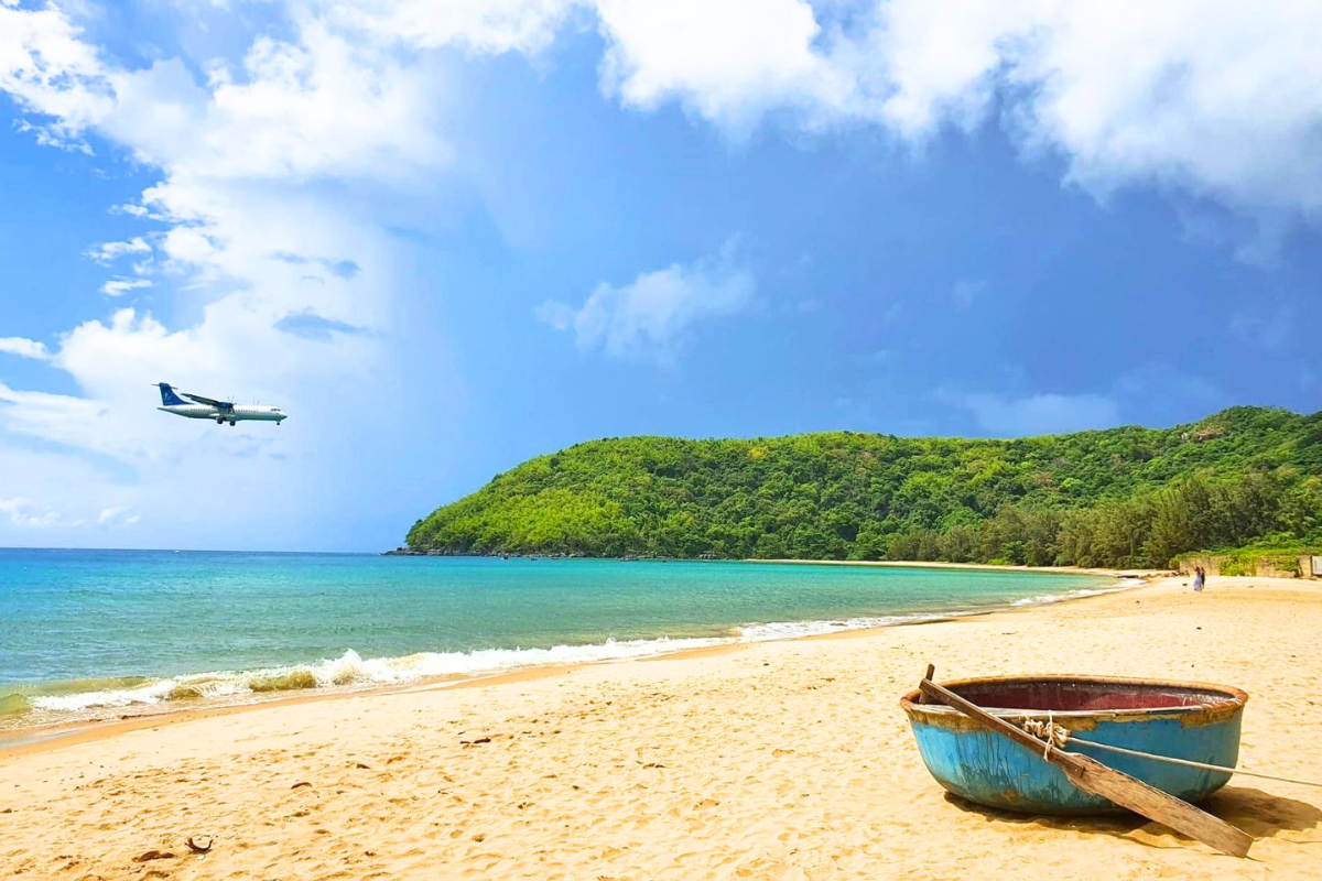 An airplane flying low above Dam Trau Beach near the airport